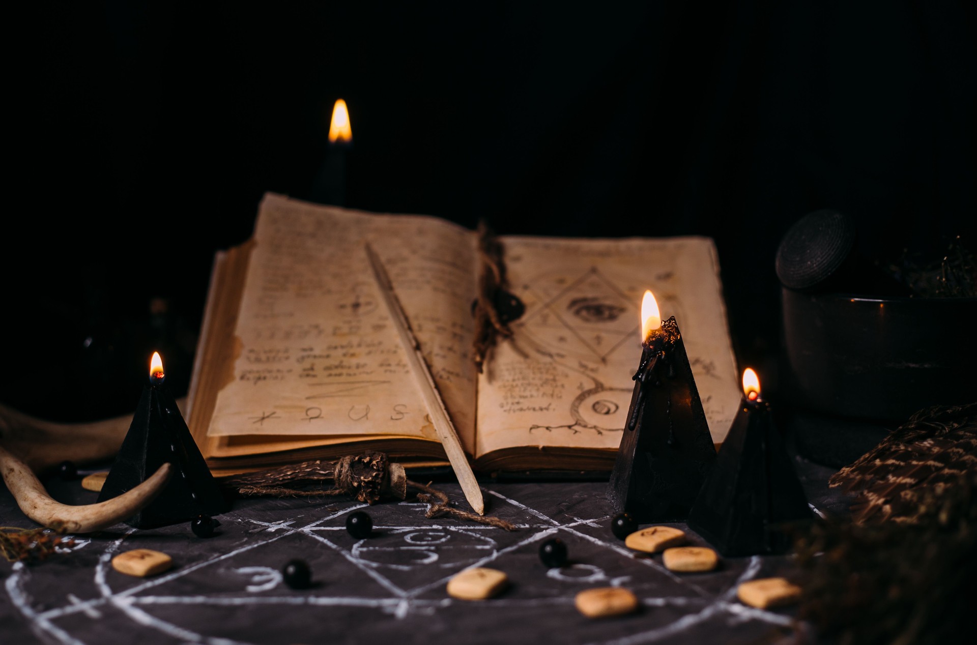 Open old book with magic spells, runes, black candles on witch table. Occult, esoteric, divination and wicca concept. Open old book with magic spells, runes, black candles on witch table. Occult, esoteric, divination and wicca concept.